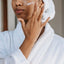 A woman applying face cream to her face, symbolizing the search for smooth, wrinkle-free skin.