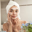 A woman applying skincare products to her face, symbolizing the importance of a daily skincare routine for maximum anti-aging benefits.